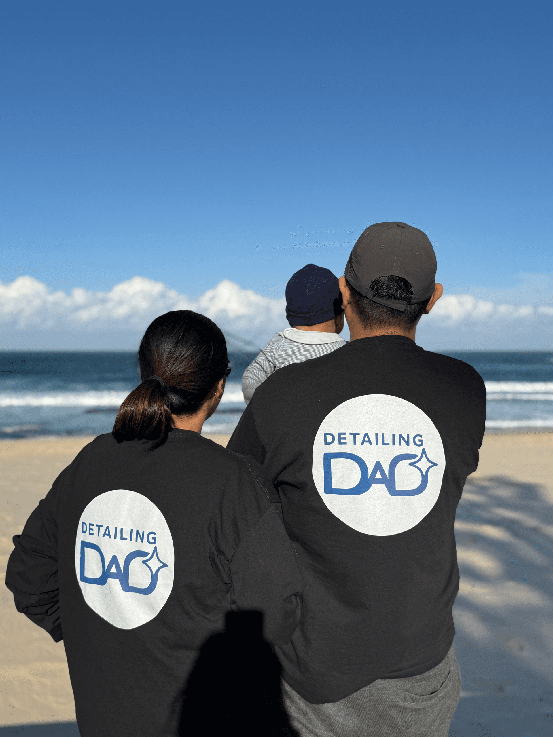 Detailing Dad and family in company uniforms by the beach